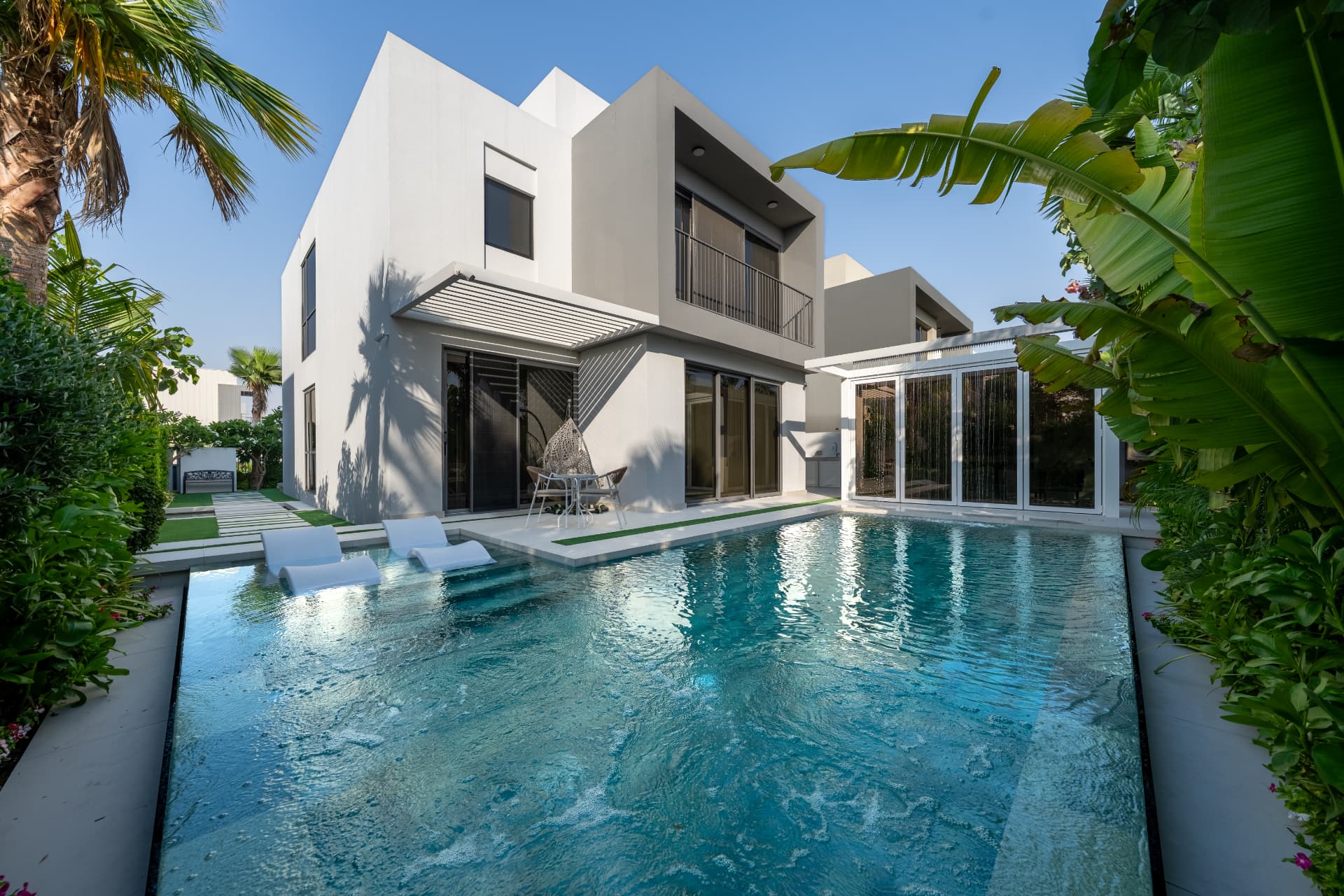 Villa 41 rear elevation by day — full pool view, terrace, pergola canopy and mature planting