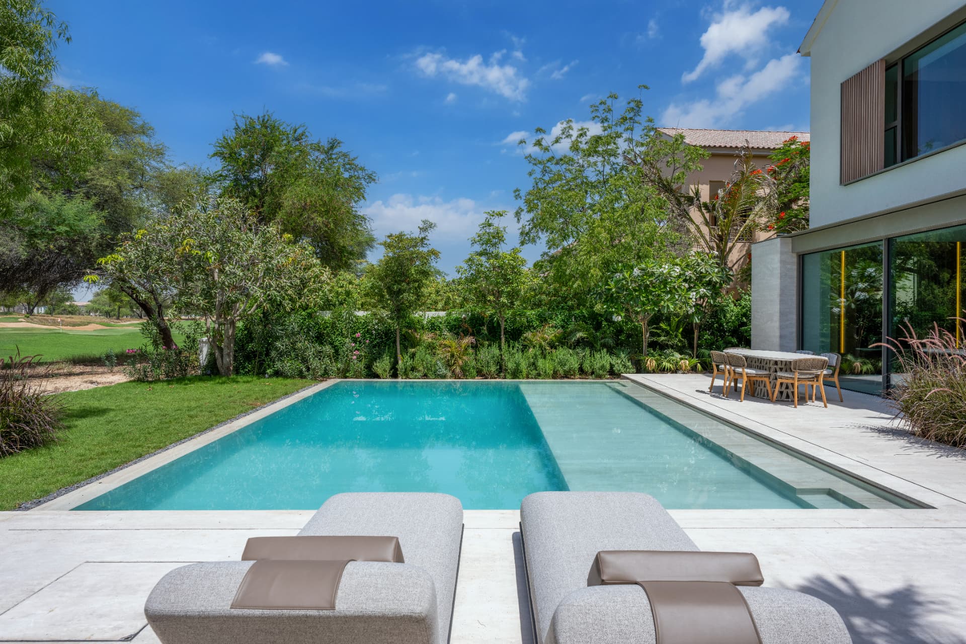 C51 — pool seen from the loungers towards the dining terrace and glazed villa façade